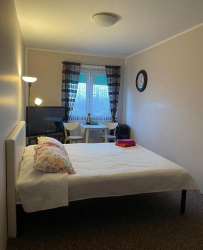 1 dormitorio con 1 cama con reloj en la pared en Pokoje Rudy Kot, en Gdynia