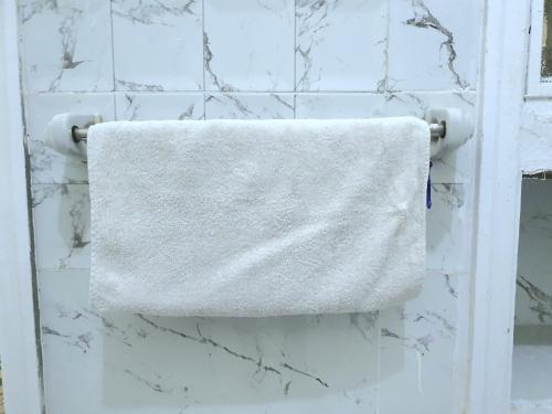 a white towel hanging on a wall in a bathroom at Special Room in downtown Cairo in Cairo
