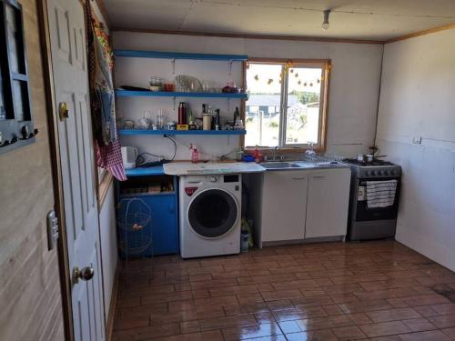 a kitchen with a washing machine and a sink at Casa en parcela in Puerto Varas