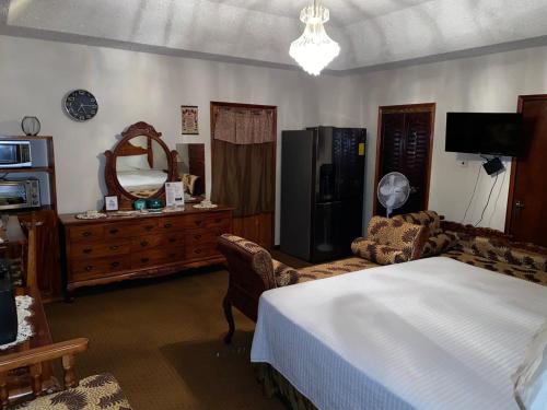 1 dormitorio con cama, tocador y espejo en Home away from home, en Mandeville