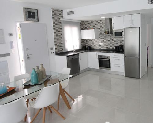 a kitchen with a stainless steel refrigerator and white cabinets at Villamar in San Pedro del Pinatar