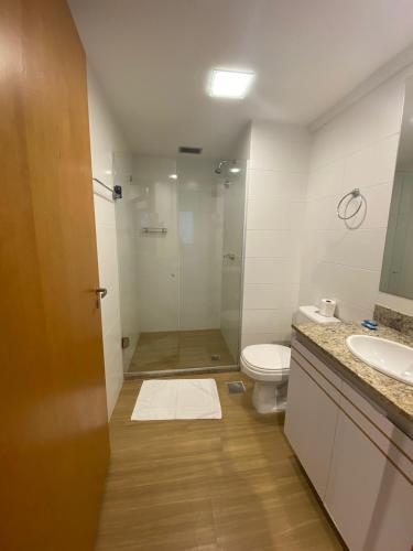 a bathroom with a shower and a toilet and a sink at Apartamento moderno e aconchegante com vista para a Esplanada in Brasília