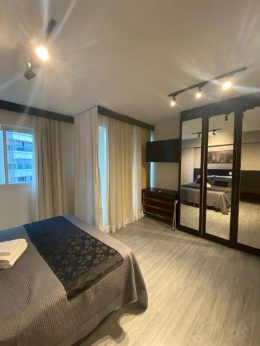 a bedroom with a large bed and a large mirror at Apartamento moderno e aconchegante com vista para a Esplanada in Brasília