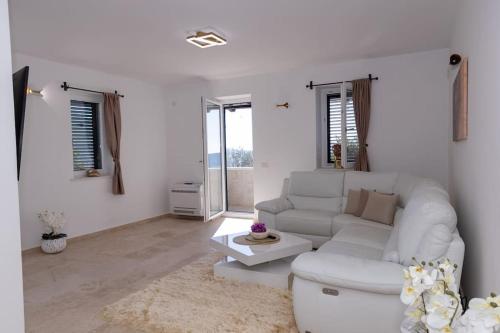 a white living room with a couch and a table at Villa Ella in Stari Bar