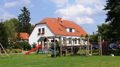 a house with a playground in the yard at Folwark Na Półwyspie in Nowe Worowo