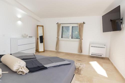 a white bedroom with a bed and a window at Villa Ella in Stari Bar