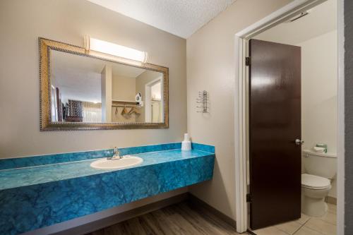 a bathroom with a sink and a mirror at Rodeway Inn & Suites Hwy 217 & 26 W in Portland