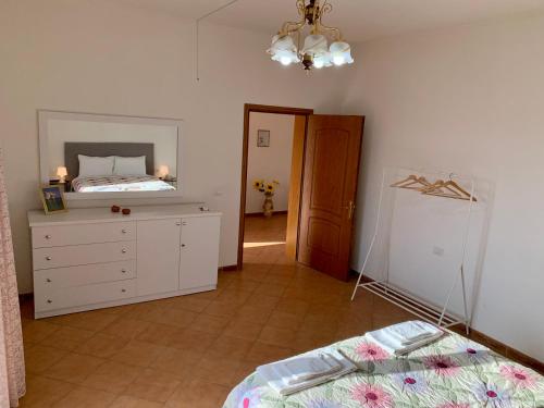 a bedroom with a bed and a dresser and a mirror at Guesthouse Villa Rosa Berat in Berat