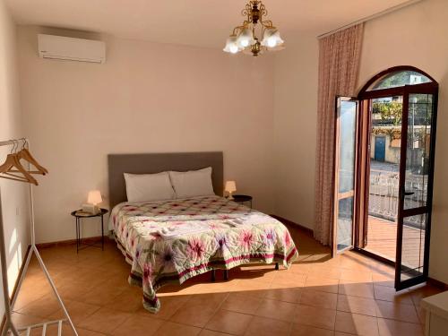 1 dormitorio con 1 cama y puerta de cristal en Guesthouse Villa Rosa Berat, en Berat