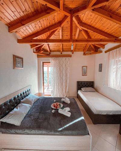 a large room with two beds and a wooden ceiling at FarmHouse Qeparo in Qeparo