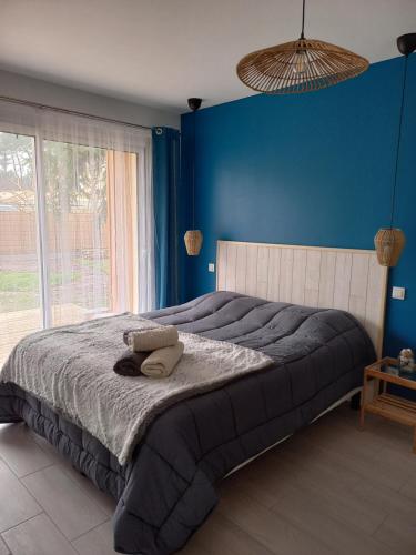 1 dormitorio con 1 cama grande y pared azul en C La Belle Vie, en Pessac