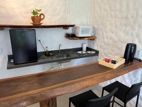 uma cozinha com um balcão com um lavatório e um micro-ondas em Casa di Maria flats em Icaraí
