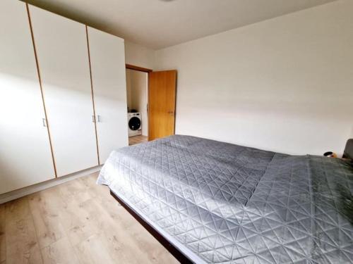 um quarto com uma cama e armários brancos em Wonderful apartment with beautiful natural pearls. em Bifrost