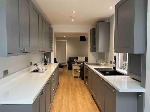 a kitchen with gray cabinets and white counter tops at May cottage in Stratford Upon Avon in Stratford-upon-Avon