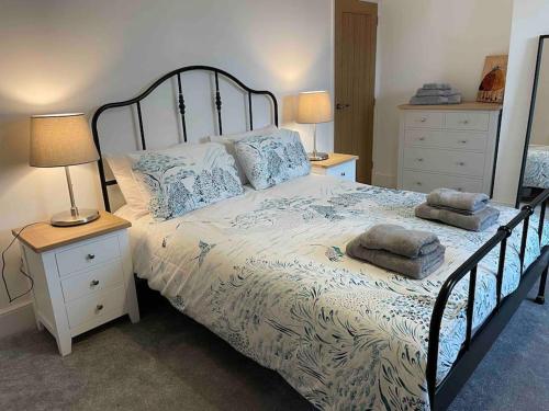a bedroom with a large bed with two night stands at May cottage in Stratford Upon Avon in Stratford-upon-Avon
