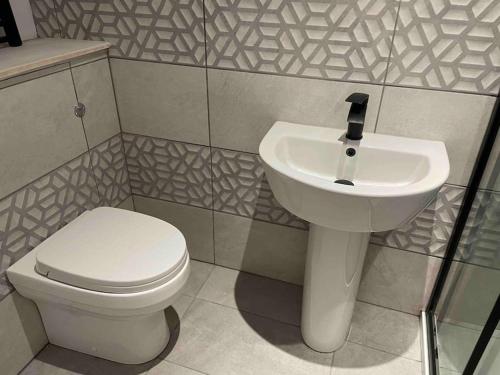 La salle de bains est pourvue de toilettes blanches et d'un lavabo. dans l'établissement May cottage in Stratford Upon Avon, à Stratford-upon-Avon