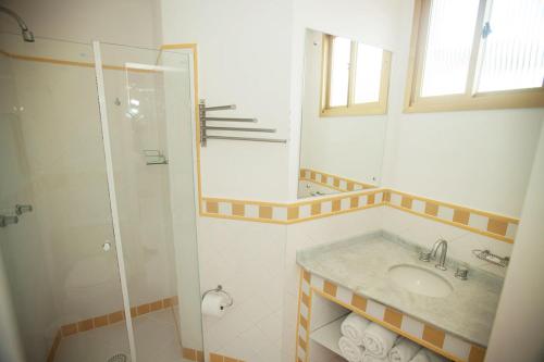 y baño con lavabo y ducha. en Entremares Residence, en Florianópolis