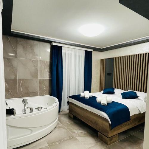 a bedroom with a bed and a bath tub at M apartmani in Lukavica