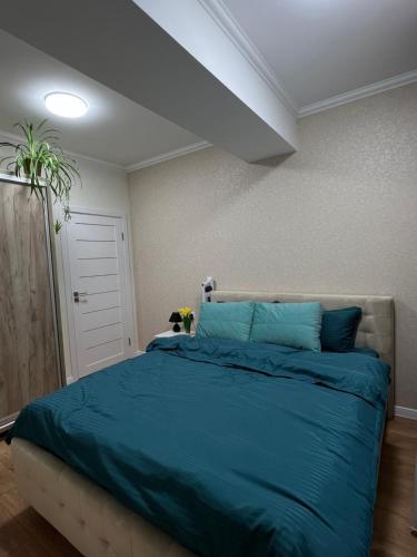 a bedroom with a large bed with blue sheets at Hi-tech aparts in Chişinău