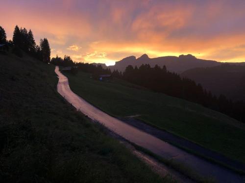 a winding road on a hill at sunset at Boutique Chalet Panoramic Views Hot Tub in Vers L'Eglise