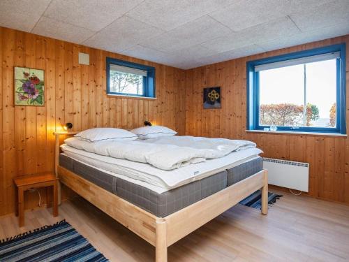 イェアティングにあるThree-Bedroom Holiday home in Esbjerg V 2の木製の壁の客室の大型ベッド1台