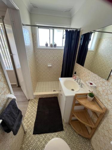 Baño pequeño con lavabo y espejo en Waterways @ North Haven, en North Haven
