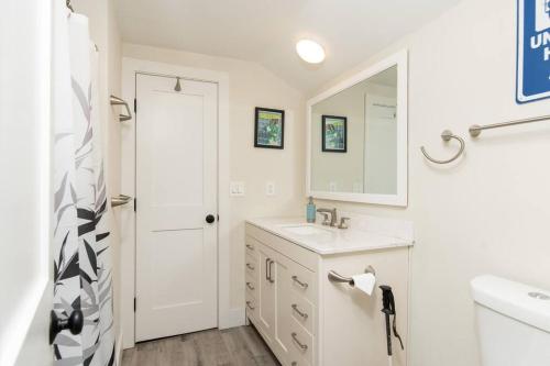 een witte badkamer met een wastafel en een spiegel bij Killington Ski Chalet - Newly Renovated in Killington