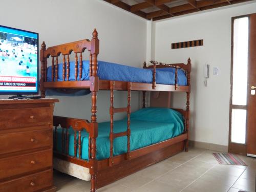 1 dormitorio con 2 literas y TV en QONDADO en Ushuaia