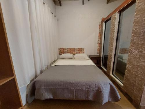 ein kleines Bett in einem Zimmer mit Fenster in der Unterkunft Larmar bed and breakfast in Puerto Princesa