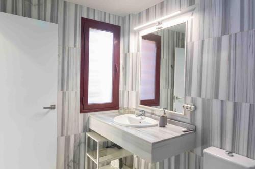 ein Badezimmer mit einem Waschbecken, einem Spiegel und einem WC in der Unterkunft VILLA rosa BENAHAVIS in Estepona