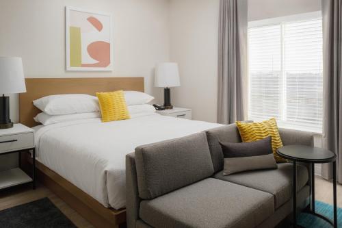 a bedroom with a bed and a couch at WaterWalk Extended Stay by Wyndham Boise Meridian in Meridian