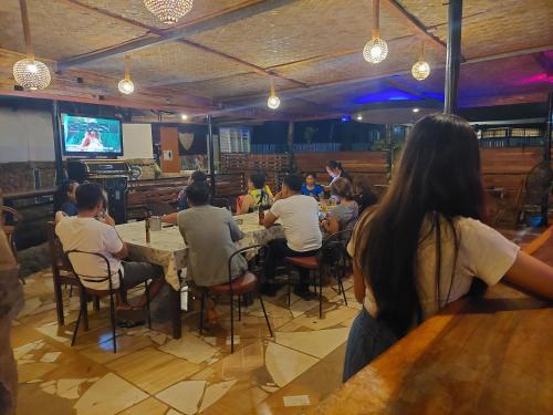 eine Gruppe von Menschen, die an einem Tisch in einem Restaurant sitzen in der Unterkunft Larmar bed and breakfast in Puerto Princesa