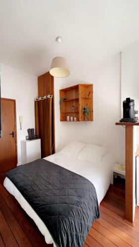 - une chambre avec un grand lit et une couverture noire dans l'établissement Reims confort, à Reims