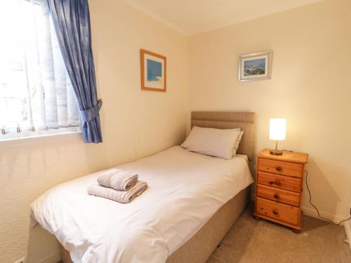 a small bedroom with a bed and a window at 1 South Snowdon Wharf in Porthmadog