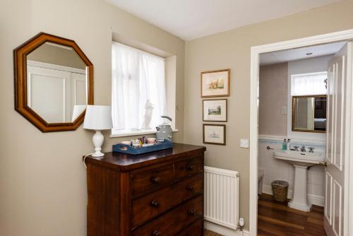 a bathroom with a dresser with a mirror and a sink at The George Inn in Oakham