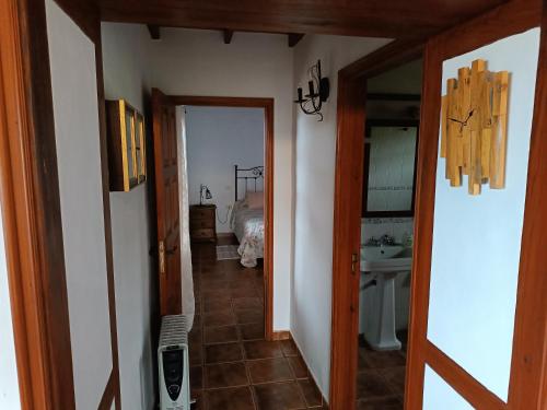 a hallway leading to a bathroom with a sink at Casa Las Caracolas in Mazo