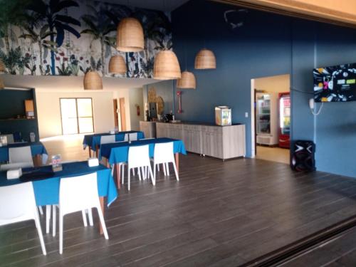 una sala da pranzo con tavoli blu e sedie bianche di Eco Resort Praia dos Carneiros - Flat 116CM, apartamento completo ao lado da igrejinha a Praia dos Carneiros