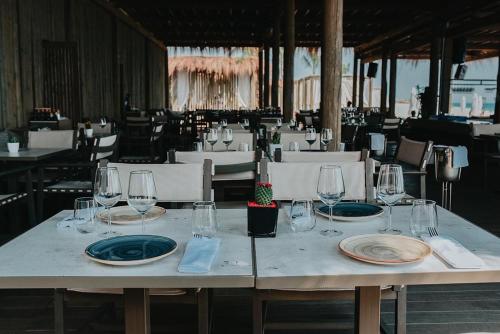 a table with wine glasses and plates on it at Heaven Residence - Green Coast Resort, Palasë in Llogara