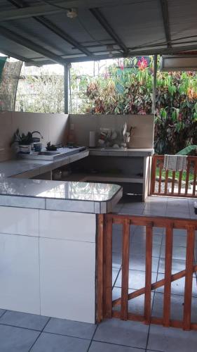 an outdoor kitchen with a counter and a table at Cabinas las Gemelas in Pavones