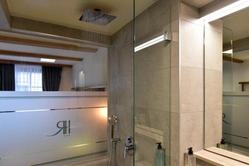 baño con ducha y puerta de cristal en Hôtel Rousseau Plus en Ginebra