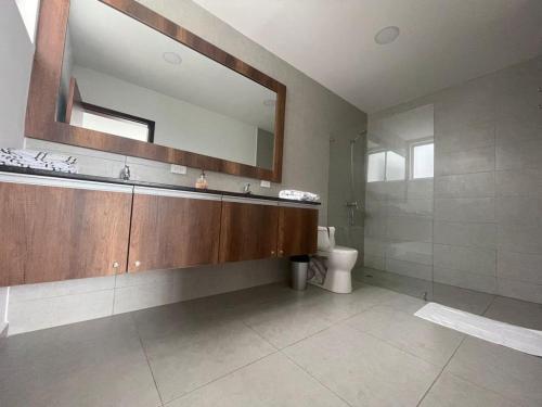 een badkamer met een wastafel, een toilet en een spiegel bij Jama Campay, Renta Casa de Lujo in Jama