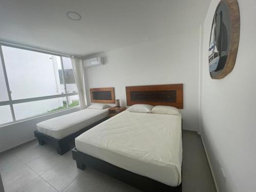 een kleine slaapkamer met 2 bedden en een raam bij Jama Campay, Renta Casa de Lujo in Jama