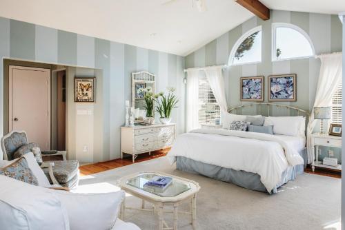 a bedroom with a bed and a chair and a table at 3485 Avalon by the Sea home in Monterey