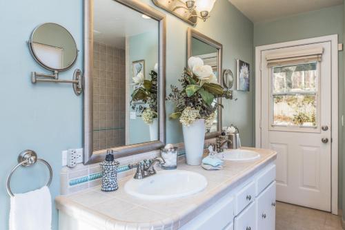 a bathroom with two sinks and a large mirror at 3485 Avalon by the Sea home in Monterey