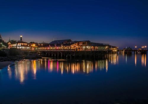 a wooden bridge over a body of water at night at 3485 Avalon by the Sea home in Monterey