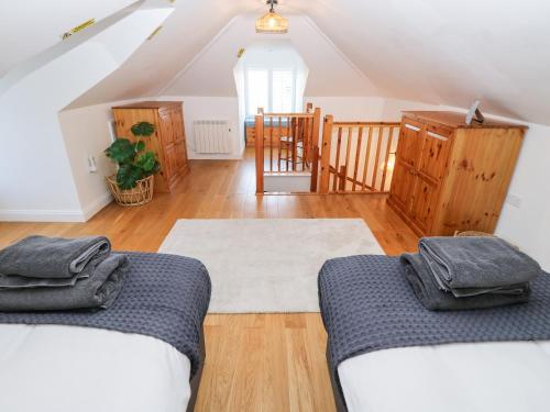 Habitación con 2 camas y escalera. en The Snug, en Totland