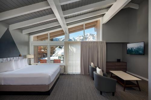 ケチャムにあるTamarack Lodgeのベッドと大きな窓が備わるホテルルームです。
