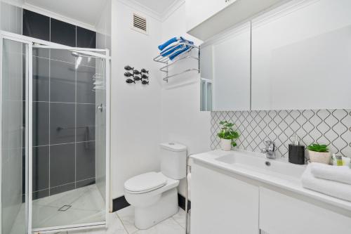 a white bathroom with a shower and a toilet at The Resort at Dolphin Heads in Mackay