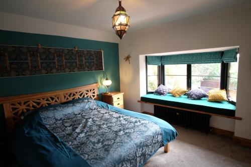 1 dormitorio con 1 cama y 2 ventanas en St Valentine - Fun away with loved ones en Manningtree