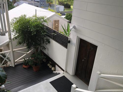 a balcony of a house with a door and plants at Shorebreak Studio Apartments in Sapphire Beach